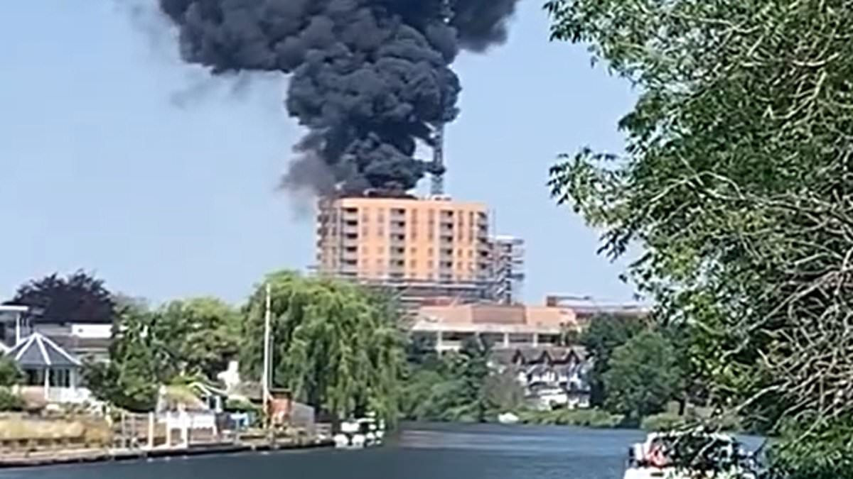 Huge fire breaks out on roof of Surrey block of flats as surrounding families are told to avoid the area [Video]
