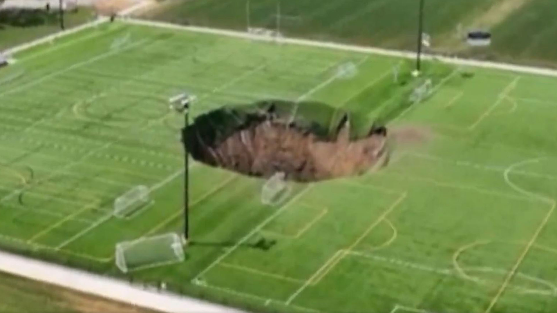 Watch horror moment soccer pitch collapses as 100-foot sinkhole swallows middle of field [Video]